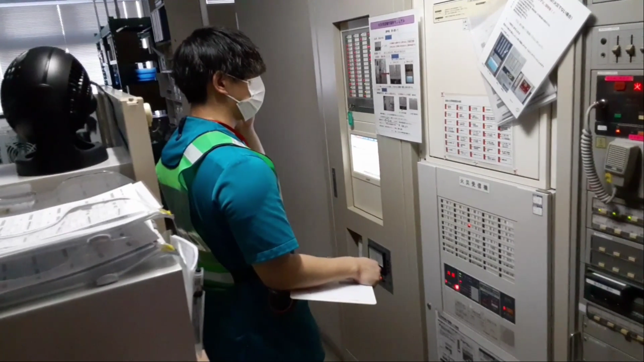 災害訓練で設備の前に立ち、対応を確認する職員